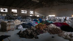 Image of a factory floor with piles of clothing